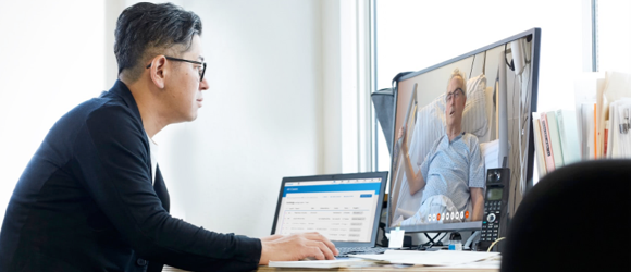 Male psychiatrist seeing a patient on his computer