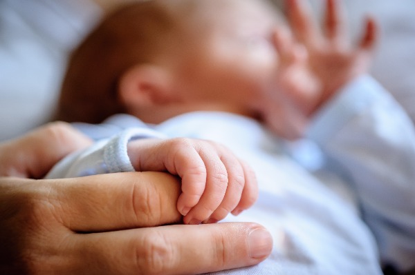 Baby holding on to mom's finger with his little hands