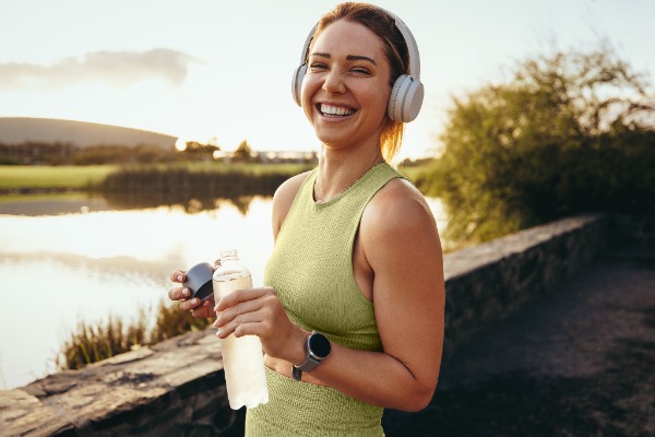 happy woman outside with her headphones on