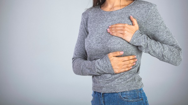 Woman holding her breast in pain