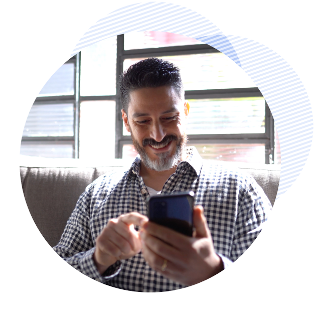 man smiling while holding his phone