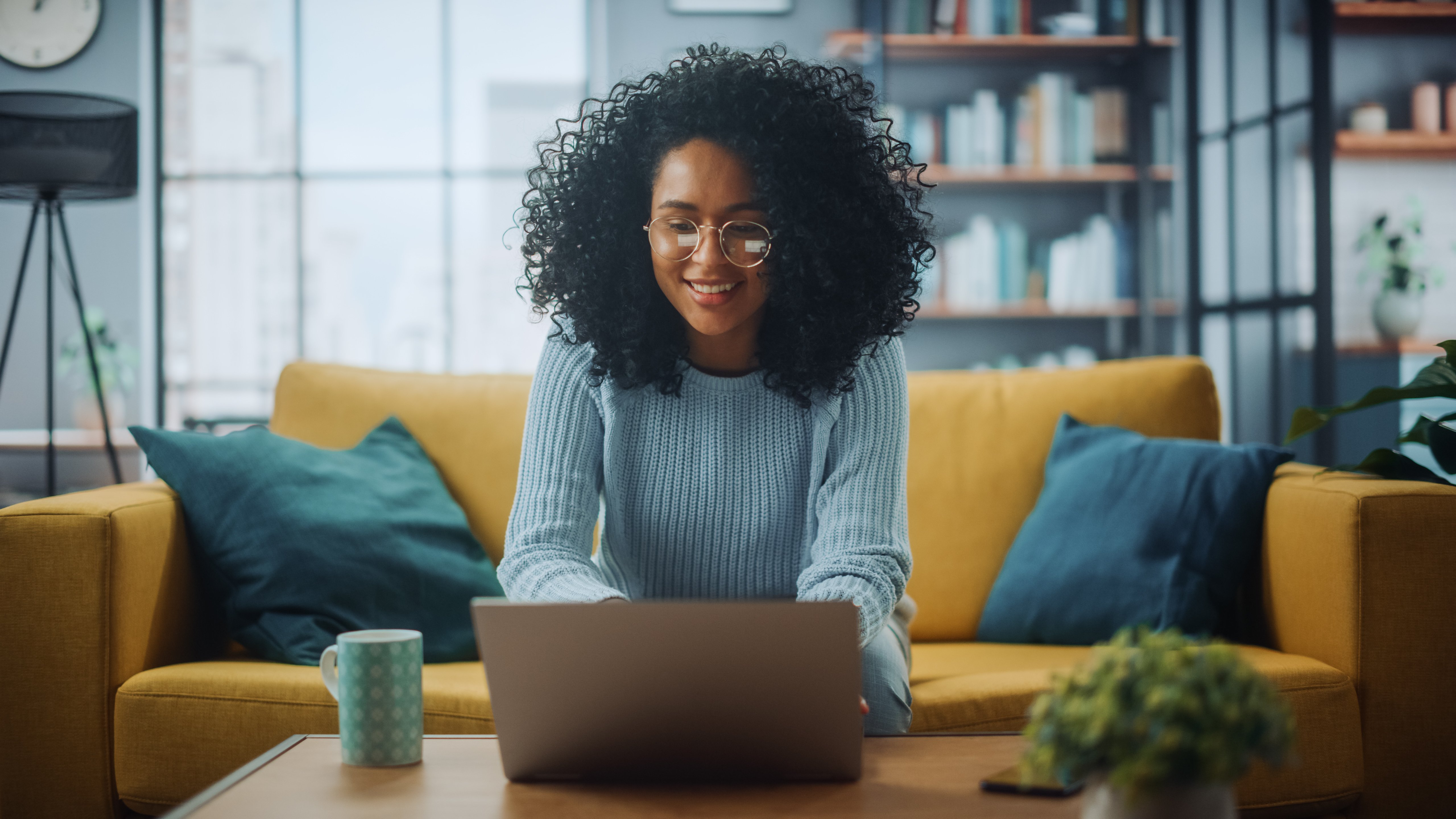 smiling young african american woman talking to a provider on her laptop